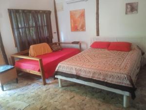 una camera da letto con un letto e una panca di cabaña en la selva a Útila