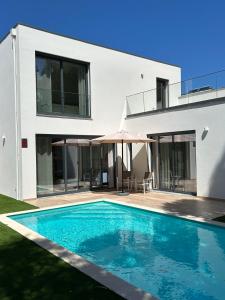 een huis met een zwembad ervoor bij Villa Pampelonne - Villa nr 7 in São Martinho do Porto