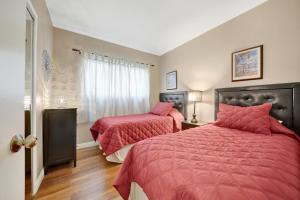 a bedroom with two beds with red sheets and a window at 3607 Seashore A & B in Newport Beach +11 photos