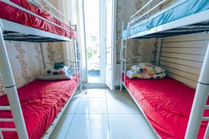 two bunk beds in a small room with red sheets at Korean Style Minbak Number Two PARIS in Paris