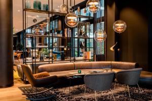 una sala de estar con un sofá y una mesa en Motel One Köln-Messe, en Colonia