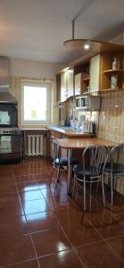 a kitchen with a wooden table and chairs in it at Casa Melcilor in Mangalia