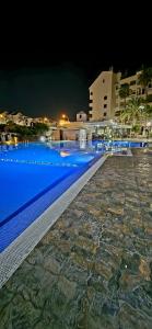 a large swimming pool with blue water at night at Studio Los Cristianos Atlantic View in Los Cristianos