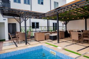 a patio with a pool and a table and chairs at Lavani Apartment in Benin City +37 photos