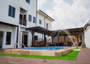 a pool in the backyard of a house with a patio at Lavani Apartment in Benin City