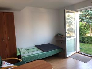 a small room with a bed and a sliding glass door at "Kubania" POKOJE GOŚCINNE in Mielno