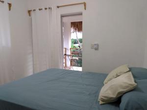 a bedroom with a bed with a blue comforter at Quédate Aquí in Las Galeras