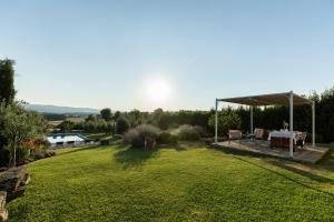 a garden with a gazebo and a table on a lawn at Nonno Gino suite in Monte San Savino