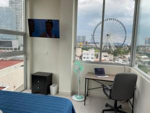 ein Schlafzimmer mit einem Bett, einem Schreibtisch und einem Rad in der Unterkunft NUEVO Penthouse para 8 en la Estrella de Puebla in El Gallinero