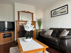 a living room with a couch and a table with flowers at Holiday House in Galway
