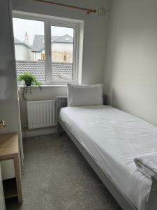 a small bedroom with a bed and a window at Holiday House in Galway +4 photos