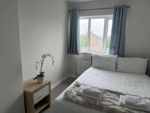 a bedroom with a bed with white sheets and a window at Holiday House in Galway