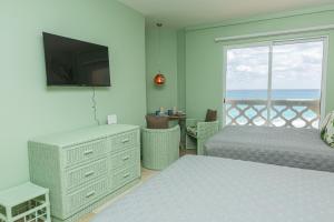 a bedroom with two beds and a balcony with the ocean at Cancun Plaza Condo Mexico in Cancún