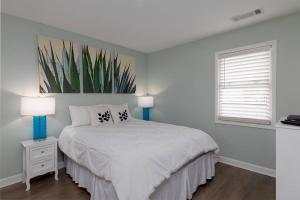 a white bedroom with a bed and two lamps at Oceanfront Resort! at Ocean Delight! in North Topsail Beach +36 photos