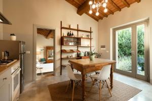 a kitchen with a wooden table and white chairs at Nonno Gino suite in Monte San Savino
