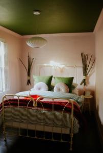 a bed in a room with a green ceiling at The Federal Inn in Maumee