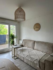 ein Wohnzimmer mit Sofa und Tisch in der Unterkunft Appartement spacieux à 30mn de Paris au pied de la gare in Saint-Ouen-lʼAumône