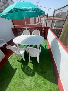a table and chairs and an umbrella on a roof at Casa JUANES in Cullera
