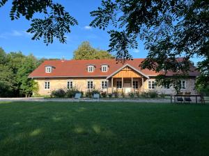 a large yellow house with a red roof at Appartment II Dwor Kuflew in Mrozy