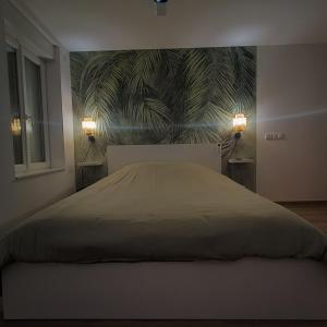 a bedroom with a large bed with a wall mural at L'Escale Châtillonnaise - L'Explorateur in Châtillon-sur-Loire