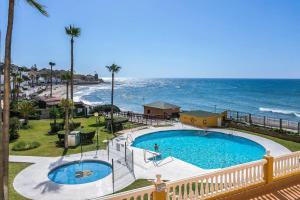 una piscina con el océano al fondo en @SeaFront, en Sitio de Calahonda