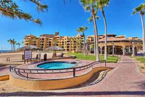a resort with a swimming pool and palm trees at Sandy Beach Princesa D107 Ocean Front Resort in Puerto Peñasco