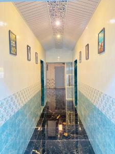 um corredor com azulejos azuis e brancos nas paredes em Military Farmhouse resort em Badlapur