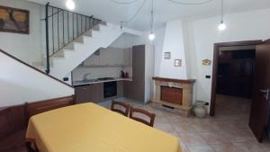 a kitchen and dining room with a table and a staircase at Casa Martino in Barisciano