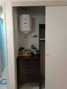 Una habitación con cocina con nevera y ventilador. en Apartamento de una habitacion con estacionamiento, en Santo Tomo