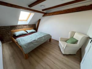 a bedroom with a bed and a chair at Apartmán Masarykovo náměstí in Děčín