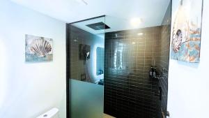 a bathroom with a shower with black tiled walls at Sky-High oasis Large Studio POOL & GYM in Miami