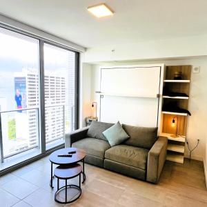a living room with a couch and a table at Sky-High oasis Large Studio POOL & GYM in Miami