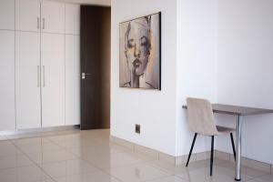 a dining room with a table and a chair at Ausblick Guest House - State House in Windhoek