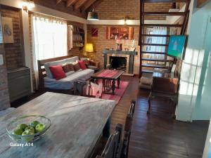 a living room with a table and a couch and a fireplace at Casa de Mimbres in El Calafate