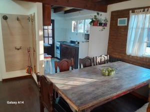 a kitchen with a wooden table and a dining room at Casa de Mimbres in El Calafate