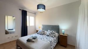 ein Schlafzimmer mit einem Bett, einem Spiegel und einem Fenster in der Unterkunft Casa Angela in Corralejo