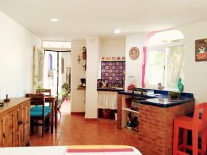 a kitchen and dining room with a brick fireplace at Casa Arbol de Paz Hab Sencilla in Chacala