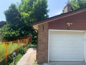 a garage with a white door and a brick house at Millpond Basement Units in Richmond Hill