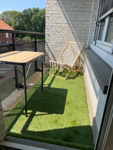 a patio with a table and a hammock on a balcony at zenitude in Marquette-lès-Lille