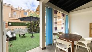 eine Terrasse mit Tisch, Stühlen und Sonnenschirm in der Unterkunft Casa Angela in Corralejo