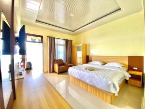 a bedroom with a large bed and a chair at Mas Cottages in Tuktuk Siadong +69 photos