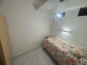 a small bedroom with a bed and a light at Apartamento en Paseo Larios de Torre del mar in Torre del Mar