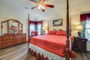 a bedroom with a red bed and a ceiling fan at San Antonio Home - Outdoor Oasis and Greenbelt Views in San Antonio