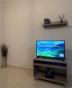 una TV a schermo piatto seduta sopra un supporto in legno di Paschali apartment with 2 bedrooms in Ammoudia a Párga