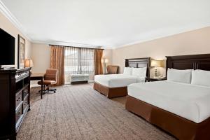 a hotel room with two beds and a flat screen tv at Best Western Ontario Mills Mall in Ontario
