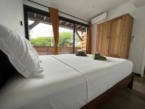 a large white bed in a room with a window at Appartement Jacuzzi - Tec-Tec 1 in Trois Bassins