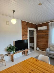 a living room with a television and a table at Rauhallinen asunto maalla, navetan päädyssä. in Muurame