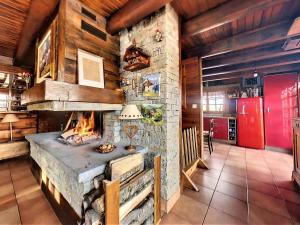 a large stone fireplace in a room with wooden walls at Chalet 4* tout confort au Corbier · Cheminée · Sauna · WiFi · Proche des pistes - FR-1-267-264 in Villarembert