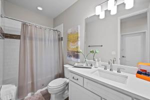Un baño con lavabo, inodoro y espejo. en Ouray Street - Commerce City, en Henderson 31 fotos más