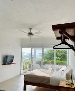 a bedroom with a bed and a ceiling fan at Casa A la Mar in Zihuatanejo